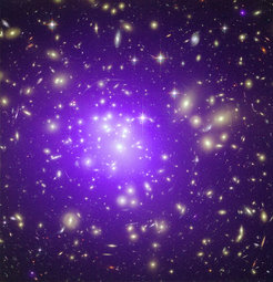The Galaxy cluster “Abell 1689”, located approximately 2 billion light years away, is one of the most massive clusters in the known Universe. This picture is a composite of an optical image, taken with the Hubble Space Telescope, and an X-ray observation with the Chandra Space Telescope. The former shows starlight from more than 1000 galaxies, the latter (in purple) the hundred-million-degree hot gas which permeates the space between galaxies and contributes more mass to the cluster than all its galaxies together.