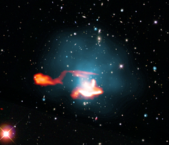 False colour image of the galaxy cluster Abell 1033, consisting of a superposition of images in the radio, X-ray and optical frequency range. The radio galaxy with its tail appears as an orange, luminous, outward-directed structure in the left part of the picture. Its tail extends to the right into the upper part of the centre of the cluster of galaxies; as the gas emits X-rays there, it is shown here in blue. This tail was made to shine again by processes in the cluster of galaxies. The bright source in the lower part of the cluster is presumably independent and has also been classified as a re-iluminated radio tail of another galaxy, i. e. another "radio phoenix".
