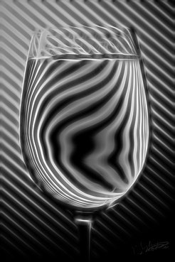 Dieses Bild zeigt die Brechung des Lichts durch ein Glas Wasser, dessen Brechungsindex für sichtbares Licht größer als eins ist.